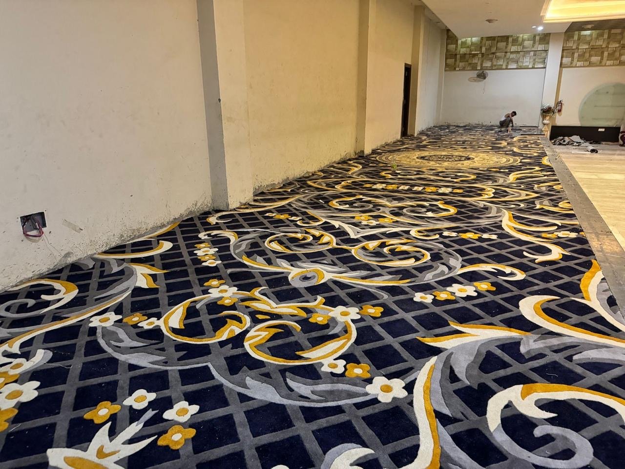 Hand-tufted blue and yellow carpet installation in Vadodara – premium hallway rug design for hotels and banquets.